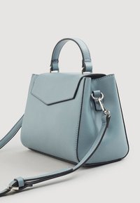 Petit sac à main structuré en simili cuir bleu clair avec une poignée supérieure, une bandoulière amovible et une fermeture à rabat. Présente des accents noirs contrastants.