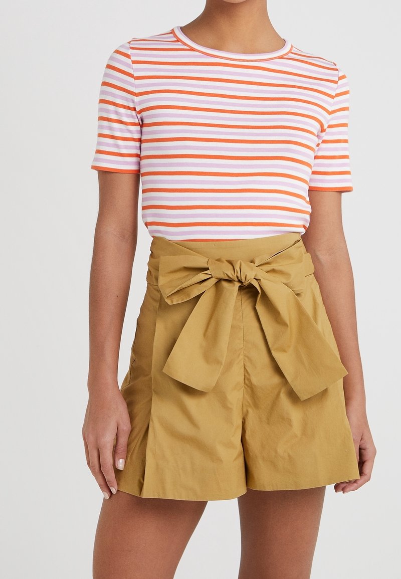 Pruhovaný top s krátkým rukávem v růžových, oranžových a bílých pruzích, doplněný o šortky v khaki barvě s vysokým pasem a mašlí vpředu.