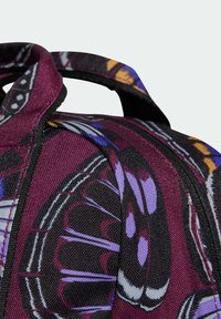 Paarse en zwarte backpack met opvallende vlindermotieven, textuurstof en zwarte hardware. Heeft dubbele draaghandvatten.