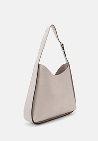 Borsa a mano beige chiaro con motivi a logo in rilievo, forma curvata e bordo nero a contrasto. Presenta una tracolla regolabile.