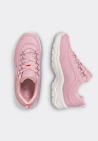 Pink sneakers with a smooth synthetic upper, white rubber sole, metal eyelets for laces, and subtle branding on the sides and tongue.