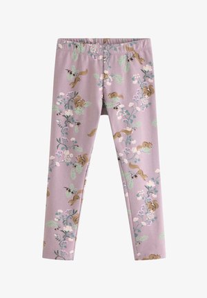 Lille barn med krøllet hår iført matchende lyse lilla jakke med blomster- og egernprint samt leggings og hvide sneakers, stående.