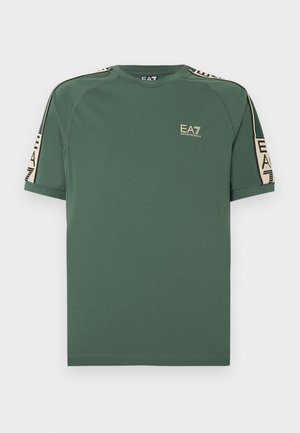 Camiseta verde de manga corta EA7 Emporio Armani con cinta beige con marca en los hombros y las mangas, logo en el lado izquierdo del pecho.