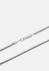 Srebrny naszyjnik z łańcuszka, składający się z gładkich, splecionych ogniw, z zapięciem typu lobster oraz prostokątnej zawieszki, na której wygrawerowano słowo "ICON".