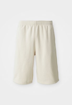 Lys beige treningshorts med elastisk midje, glatt tekstur og subtil logo detalj på nedre venstre side. Ingen lommer.