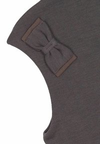 Hnedý pletený odev s textúrovanou tkaninou a jedinou mašľou na pleci, zdôrazňujúci jednoduchosť a jemnosť v dizajne.