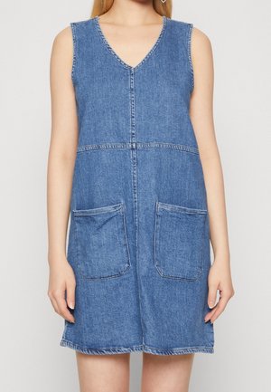 Jumpsuit denim tanpa lengan, desain V-neck, warna biru muda, dilengkapi dengan dua kantong depan, jahitan yang terlihat, dan bentuk A-line.