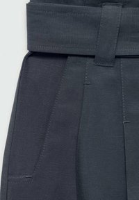 Pantalones de color gris oscuro que presentan una textura suave, un diseño plisado y una cinturilla ancha con un lazo para cinturón. Incluye bolsillos laterales.