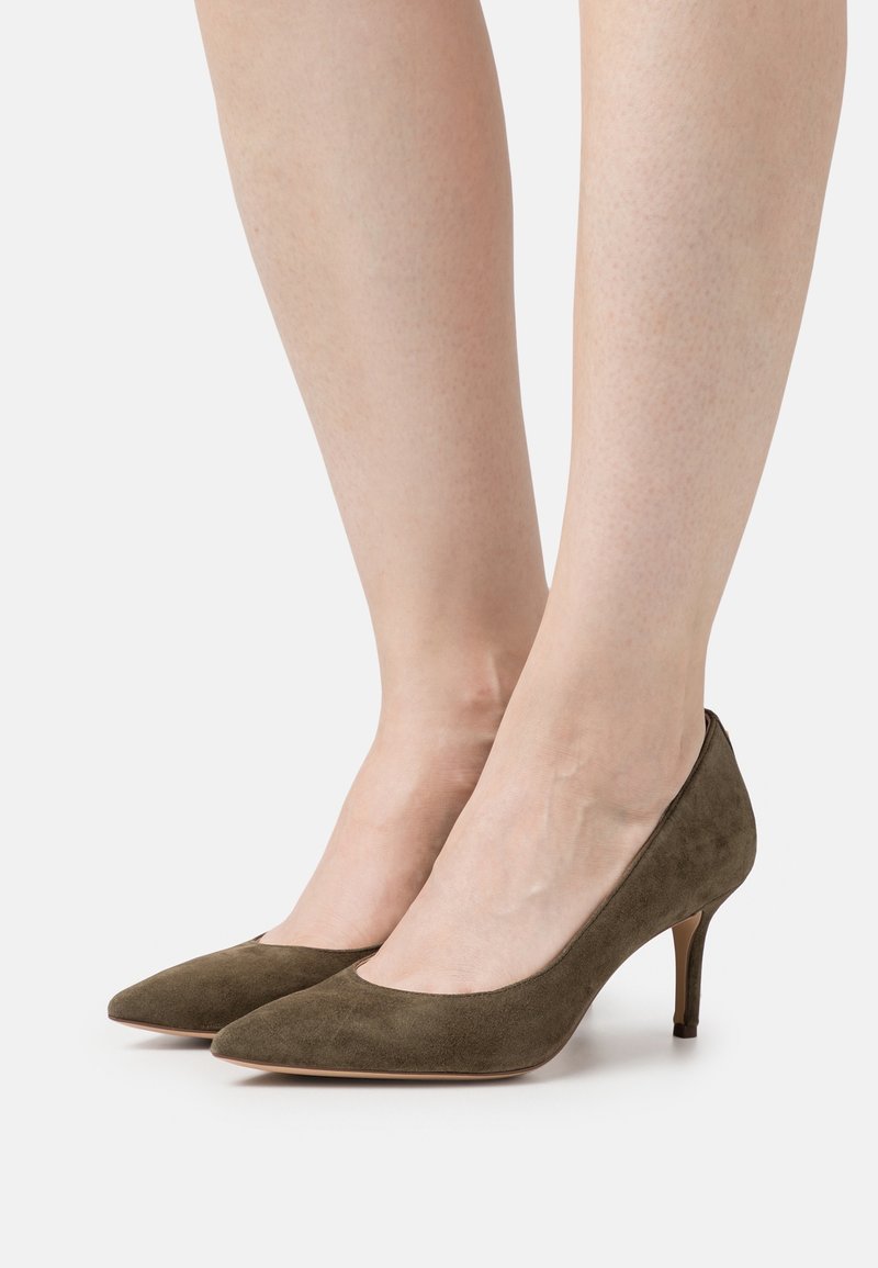 Olivgrön mocka högklackade skor med spetsig tå och smal klack, med en slät yta och en lågskuren design längs sidorna.