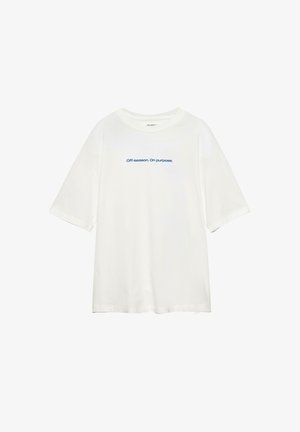 Biała oversize koszulka z niebieskim napisem na środku klatki piersiowej: "Poza sezonem. Celowo."