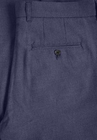 Pantalones de tejido azul marino con un único bolsillo trasero, con cierre de botón negro y detalles de costura sutiles.