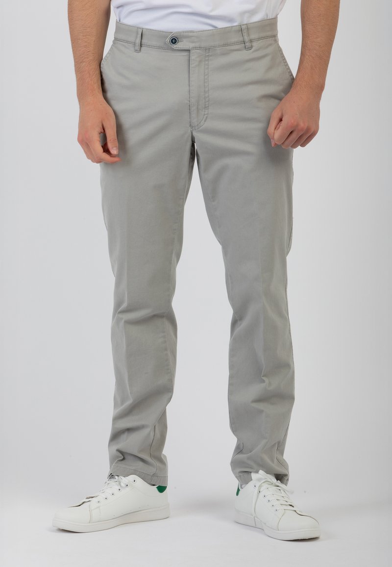 Pantaloni in cotone grigio chiaro con un design a gamba dritta, dotati di chiusura frontale con bottone e tasche laterali, abbinati a sneakers bianche.