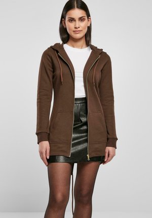 Brun zip-up hettegenser med fork pockets, med hette og lette snor, kombinert med svart skinn miniskjørt.