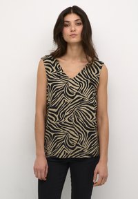 Haut sans manches avec un col en V, présentant un motif zèbre noir sur fond beige. Fabriqué en tissu léger avec une coupe décontractée.