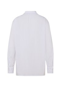 White long-sleeve shirt with a collar, featuring subtle texture and stud detailing near the cuffs. Smooth fabric and relaxed silhouette.