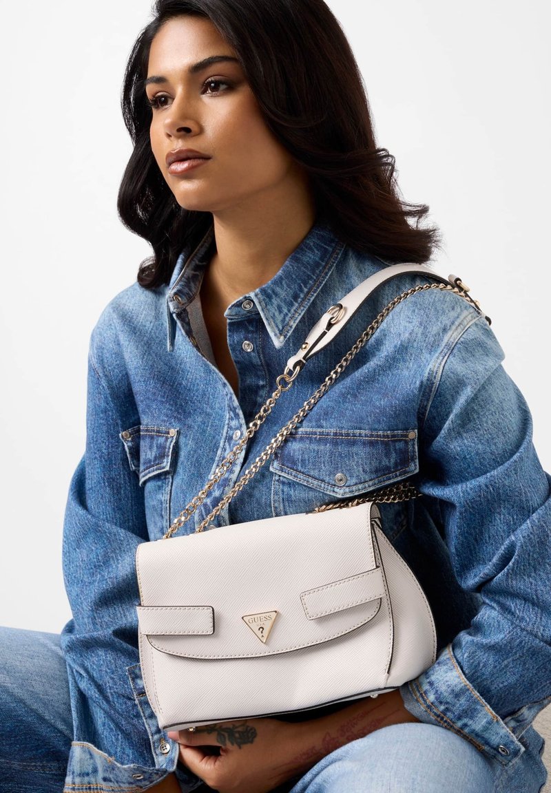 Borsa a tracolla in pelle bianca con una forma strutturata, dotata di chiusura a patta, tracolla a catena e dettaglio logo tono oro.