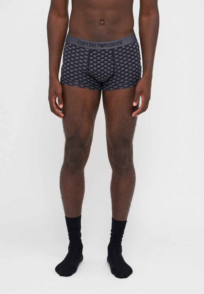 Boxers noirs avec un motif de logo répété, ceinture élastique avec le texte "Emporio Armani", fabriqués à partir d'un tissu doux et extensible.