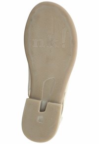 Béžová podešev sandálu s texturovanou gumou, s výřezovým designem a vyvýšeným logem. Hladký povrch s horizontálními drážkami pro záběr.