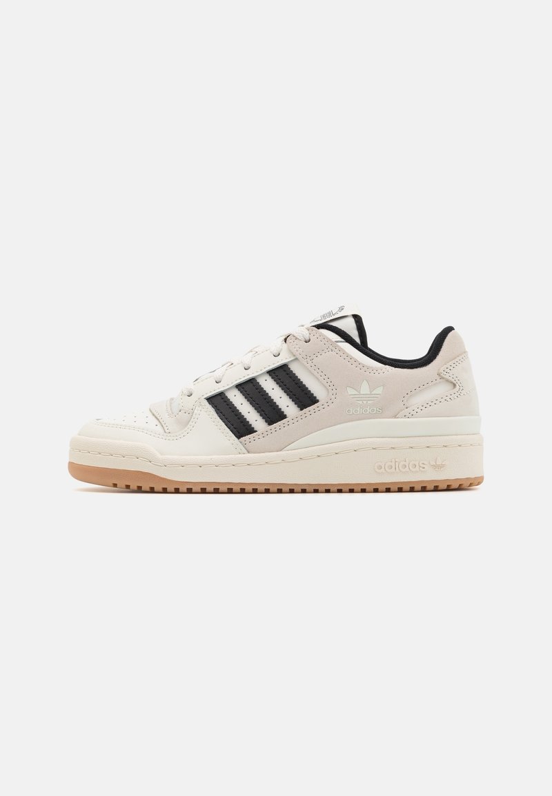 Light beige sneakers with black stripes and branding, rubber sole, leather and textile upper, perforated details, and a rounded toe design.