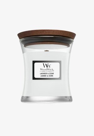Glazen WoodWick geurkaars met houten deksel, gelabeld met de geur Lavendel & Ceder, witte was aan de binnenkant.