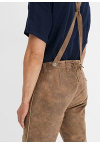 Pantaloni marroni con texture, dotati di bretelle regolabili color marrone. Presentano una vita con coulisse e dettagli con bottoni. Vestibilità standard con tasche laterali.