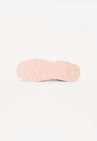 Semelle de chaussure avec un design en caoutchouc texturé, principalement rose avec des accents beige clair et un profil de semelle pour une meilleure adhérence et stabilité.
