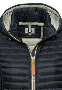 Puffjacke aus recyceltem Material, marineblaues Äußeres, beigefarbenes Innenfutter, mit Reißverschluss, gerippten Akzenten und Kapuze.