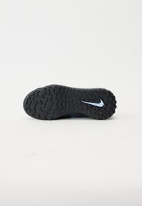 Fekete gumitalp, textúrált felülettel, kék Nike logóval és hullámos mintázattal a tapadásért.