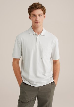 Light gray polo shirt with a classic collar, short sleeves, and a small chest pocket. Made of smooth fabric with a relaxed fit.