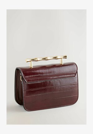 Bordó lakkbőr borítéktáska merev formával, arany színű bambusz stílusú fogantyúval és vízszintes texturált részletekkel.