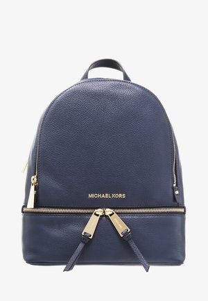 Sac à dos Michael Kors en cuir bleu marine avec fermetures éclair et logo dorés, équipé de deux curseurs de fermeture éclair et d'une poignée supérieure.