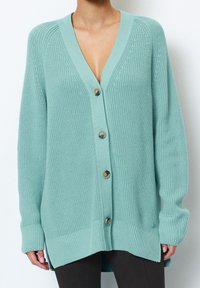 Mint green cardigan featuring a deep V-neck, chunky knit texture, five buttons down the front, and ribbed cuffs and hem.