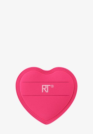 Lyserødt hjerteformet silikone-unde varmepude med teksturerede kanter og "RT"-logo i midten på hvid baggrund.