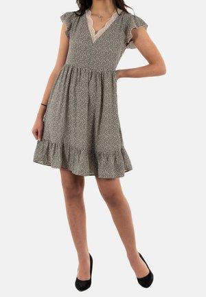 Vestido con estampado en blanco y negro, con mangas cortas con volantes, escote en V y bajo acampanado. Cuenta con ribete de encaje alrededor del escote.