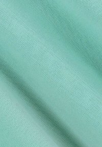 Tissu bleu-vert clair avec une texture lisse, présentant un motif de tricot fin et un subtil éclat, tombant doucement en plis.