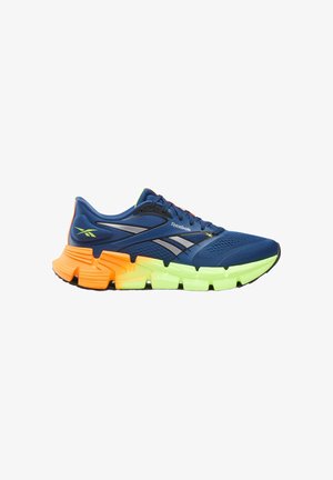 Blauwe Reebok hardloopschoen met gelaagde oranje en neongele zool, ademend mesh bovenwerk en zilverkleurig logo aan de zijkant.