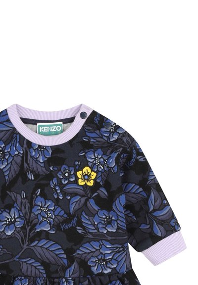 Robe noire à fleurs avec des motifs bleus et violets, accentuée par une fleur jaune. Comprend un col rond en lilas côtelé et une fermeture à boutons-pression.