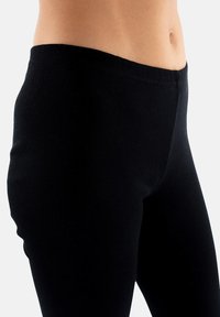 Czarne legginsy o gładkiej fakturze i wysokim fasonie w talii, z dopasowanym krojem i bezszwowym wykończeniem od talii do kostki.