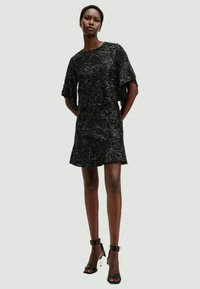 Black sequin short dress with a relaxed fit, short sleeves, and a flared silhouette. Features a round neckline and smooth fabric texture.