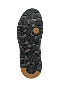 Suela de goma negra con patrones circulares y un acento marrón. Diseñada para la transpirabilidad con superficies texturizadas para agarre y flexibilidad.