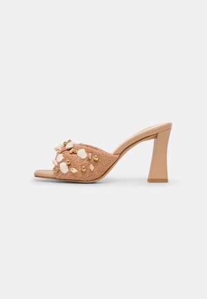 Beige højhælet mule med vævet tekstur, dekoreret med hvide blomster- og guldbedeprydelser på frontremmen.
