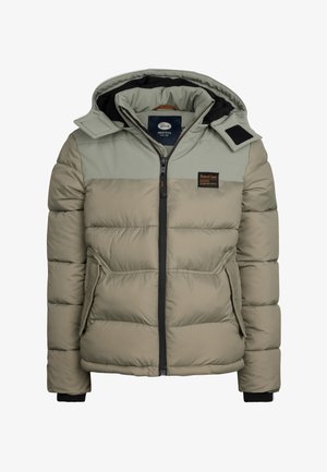 Chaqueta de plumas caqui con costuras horizontales, capucha y bolsillos frontales. Combinada con jeans azules y zapatillas negras con acentos blancos.