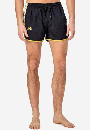 Shorts da bagno neri con accenti gialli, vita con cordino e branding laterale. Realizzati in materiale leggero, con una texture liscia.