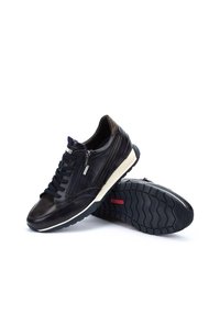 Sneaker in pelle nera con accenti testurizzati, design con lacci, zip laterale e suola intermedia bianca. La suola in gomma presenta un motivo a zigzag.