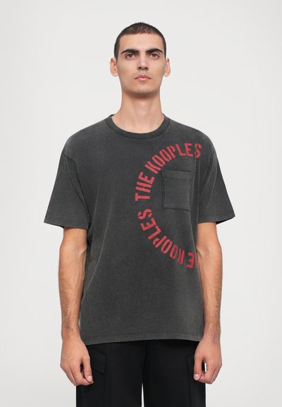 Dark gray cotton t-shirt with short sleeves, featuring a circular red graphic text design and a small chest pocket.
