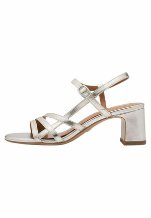 Sandalo con tacco a blocco in metallo argento, con più cinturini incrociati, fibbia alla caviglia, punta aperta e tacco robusto per la stabilità.