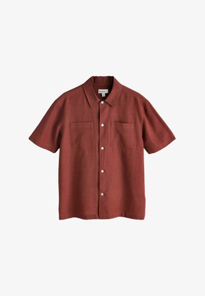 Rövid ujjú, rozsdaszínű ing könnyű anyagból, két elülső zsebbel és fehér gombokkal a gombsor mentén.