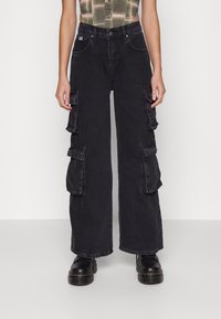 Svarta cargobyxor med lös passform, som har flera sidofickor, hög midja och kontrasterande sömmar. Tillverkade av denimstoff.