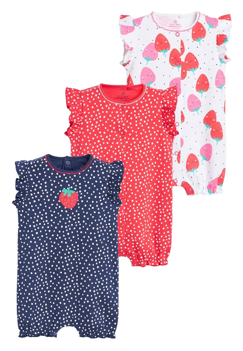Trois combinaisons pour bébé : une navy avec des pois blancs et un patch de fraise, une rouge à pois, et une blanche avec des fraises roses. Manches à volants.