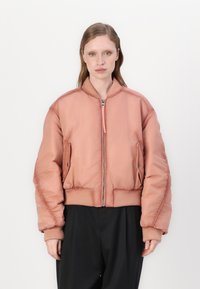 Light pink bomber jacket with a zip front, ribbed cuffs and hem, and side pockets. Smooth texture with padded, voluminous design.